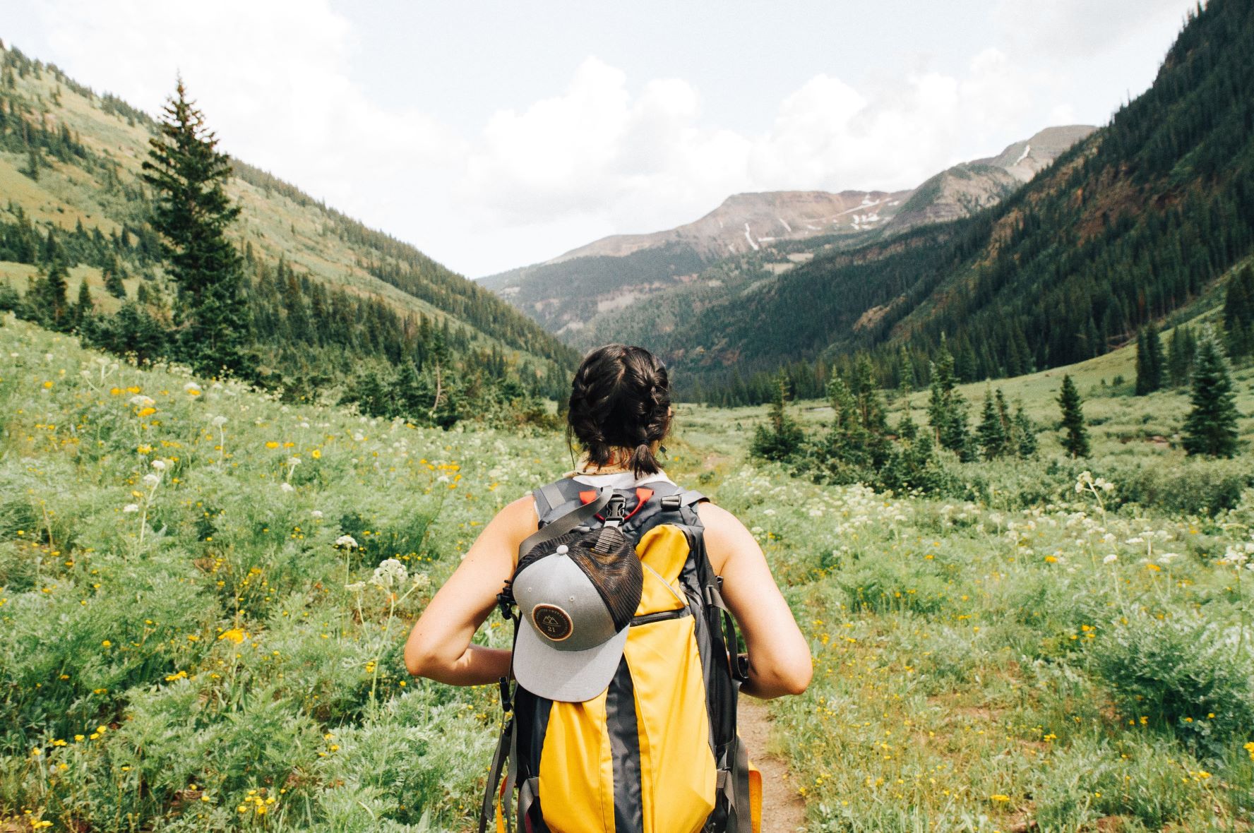 hiker on path looking at mountains ahead